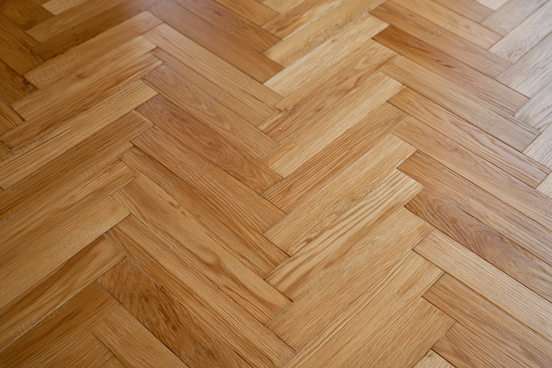 Herringbone parquet wood floor with natural grain pattern in interior space