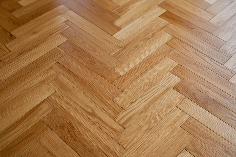 Herringbone parquet wood floor with natural grain pattern in interior space