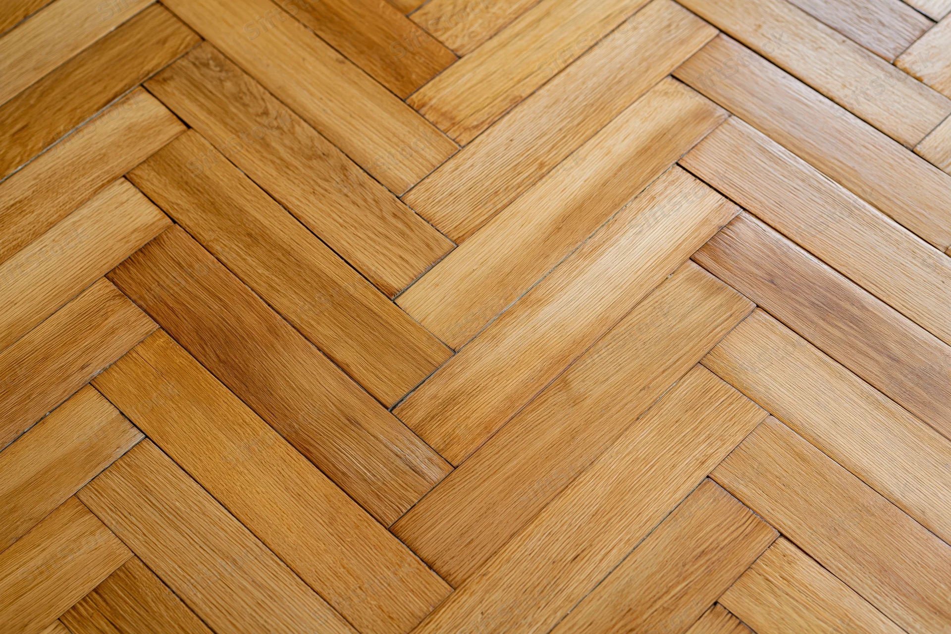 Herringbone parquet wood floor with natural grain pattern in interior space