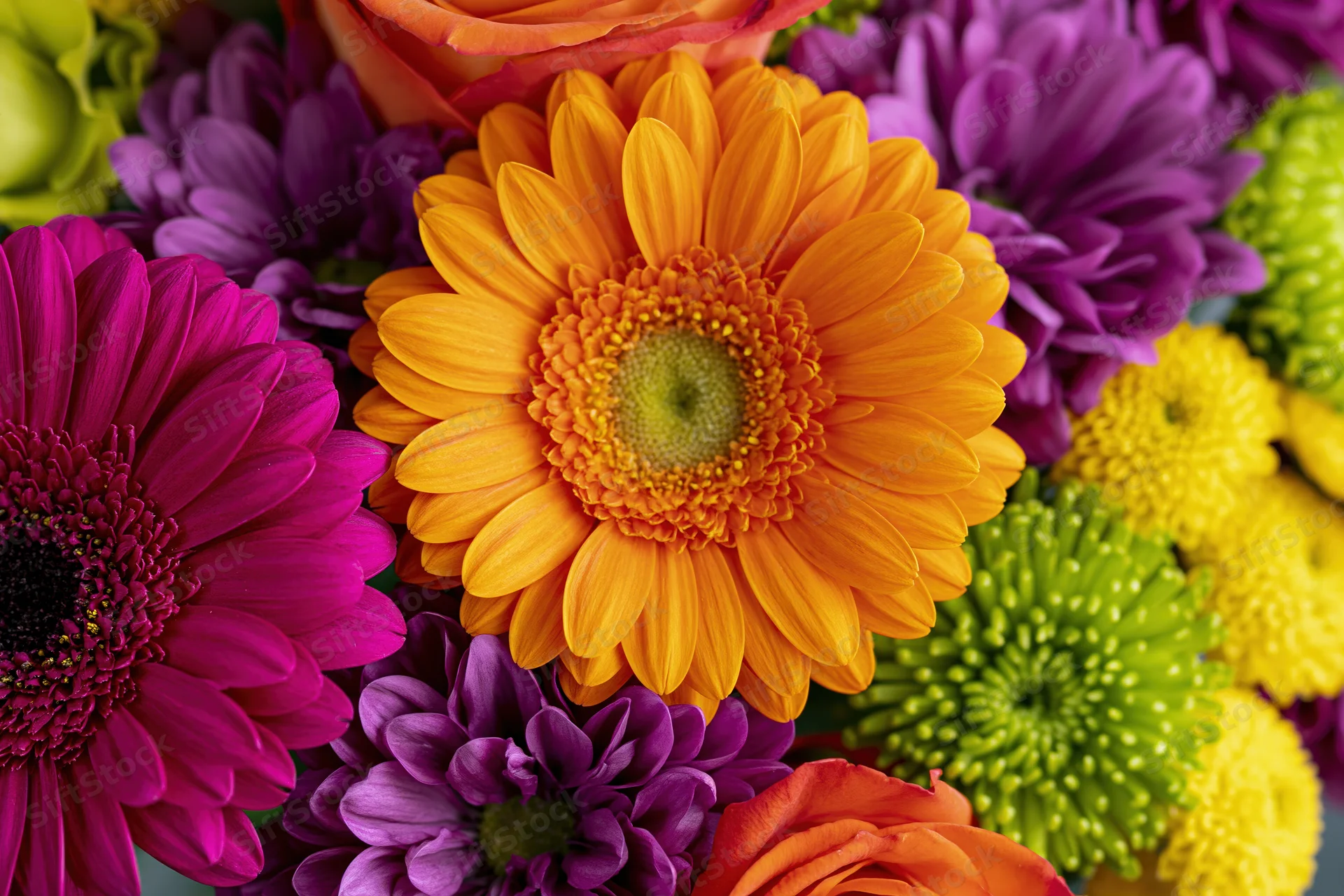 Close-up overhead view of a colorful mixed flower bouquet with gerbera daisies and chrysanthemums arranged together