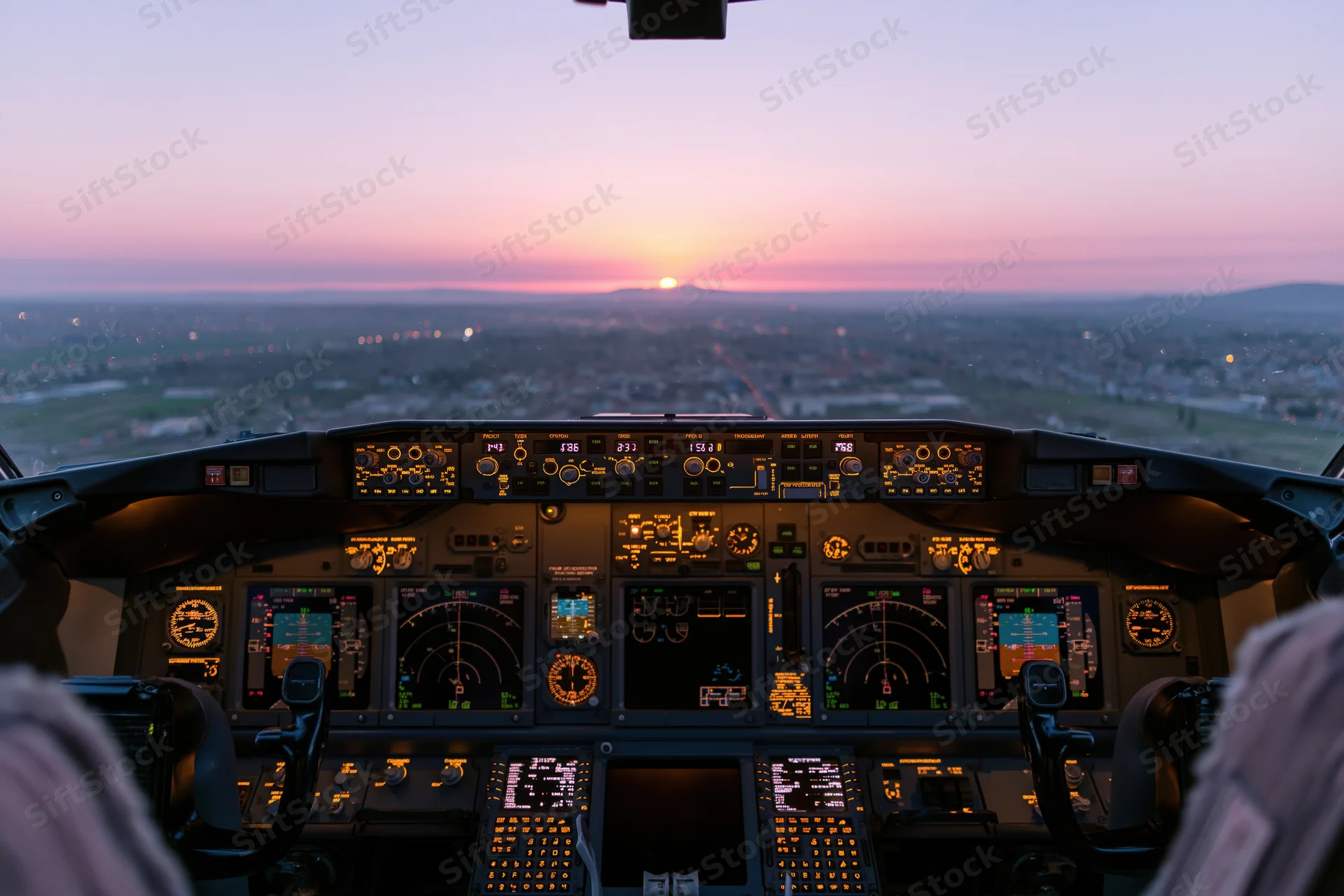 Commercial airliner cockpit interior at sunrise with illuminated instruments and city view ahead