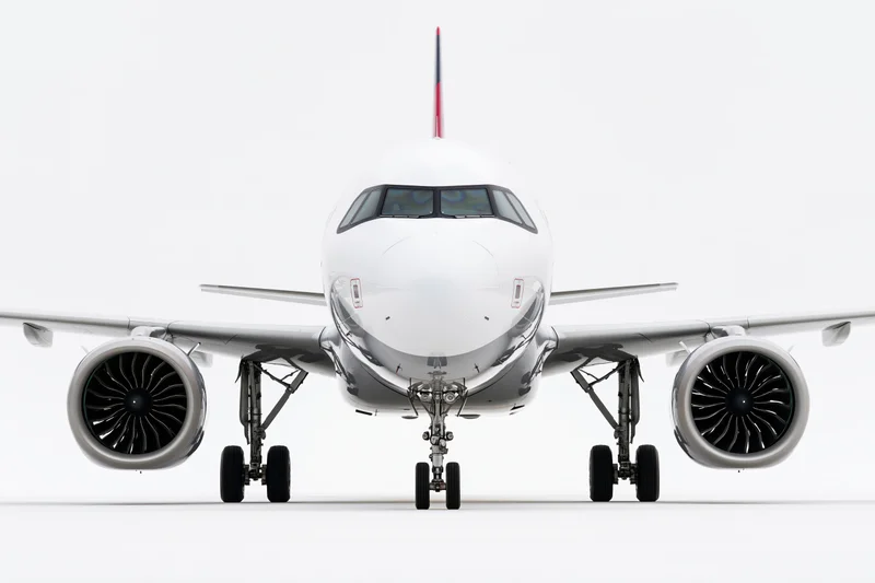 Commercial passenger jet viewed head-on from ground level on white background