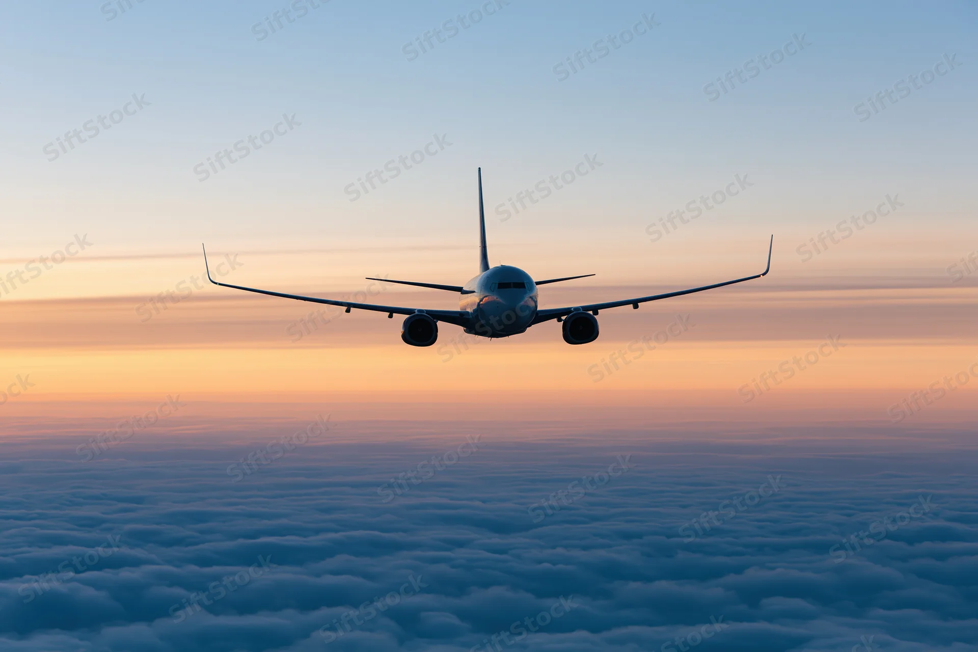 Commercial passenger jet flying above dense cloud layer at twilight