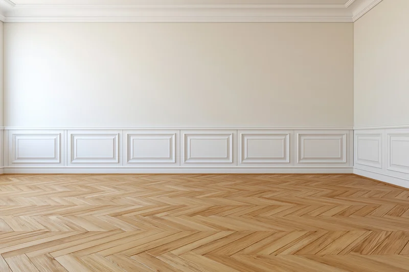 Empty classic interior room with white wainscoting panels and herringbone wood flooring