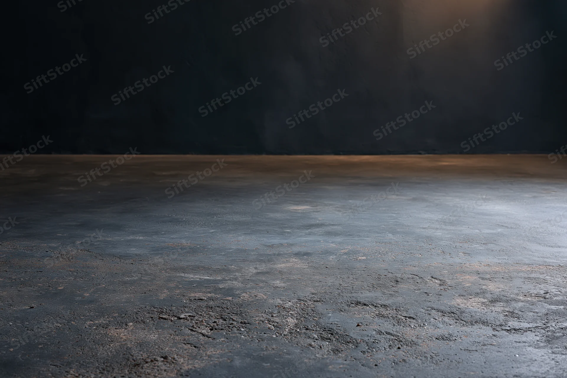 Empty concrete floor meeting dark bare plaster wall in industrial interior space