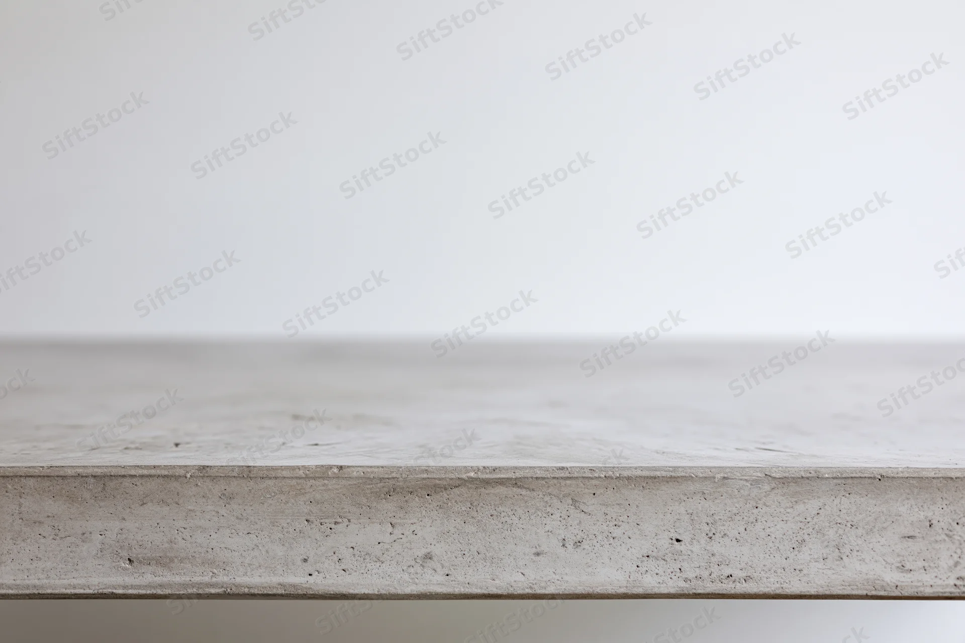 Empty concrete tabletop viewed straight on from low angle with clean edge and neutral surface