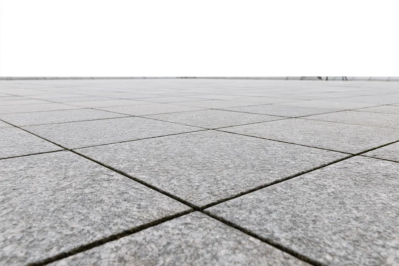 Gray concrete tiles arranged in a grid pattern across an outdoor plaza floor stretching to a white horizon