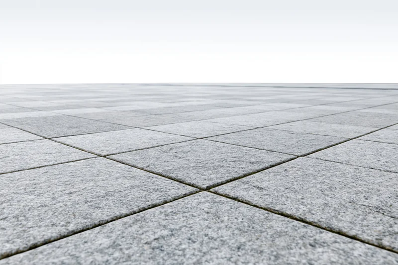 Gray concrete tiles arranged in a grid pattern on an empty outdoor plaza floor stretching to a white horizon