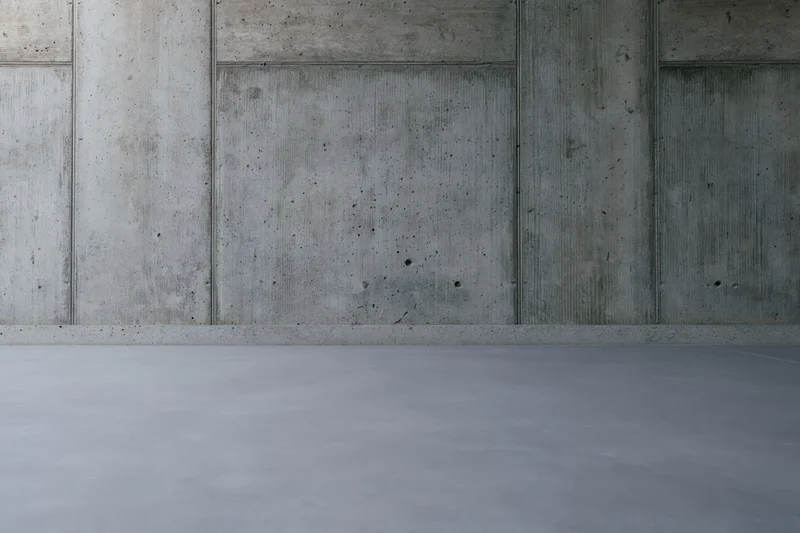 Empty concrete wall and floor interior with smooth gray surfaces and visible seams