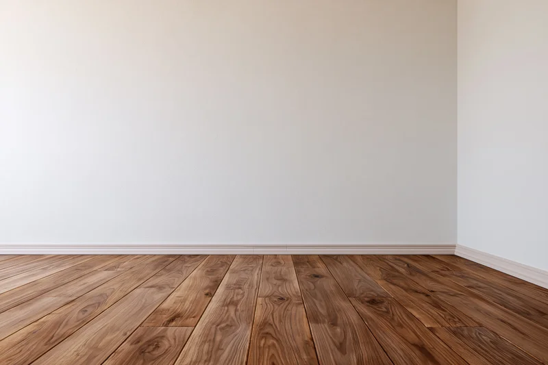 Empty interior room with white walls and wooden floor meeting at corner