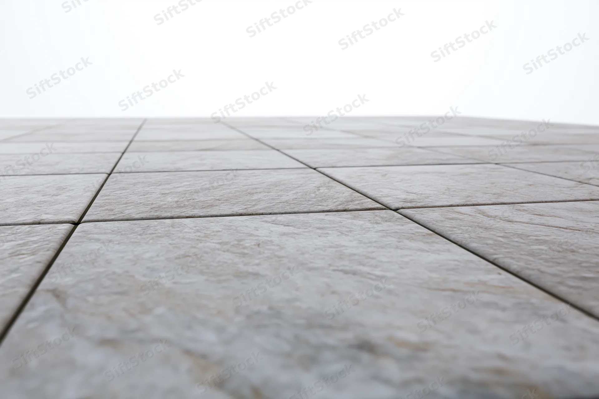 Light grey stone tiles arranged in a receding perspective on a flat outdoor floor