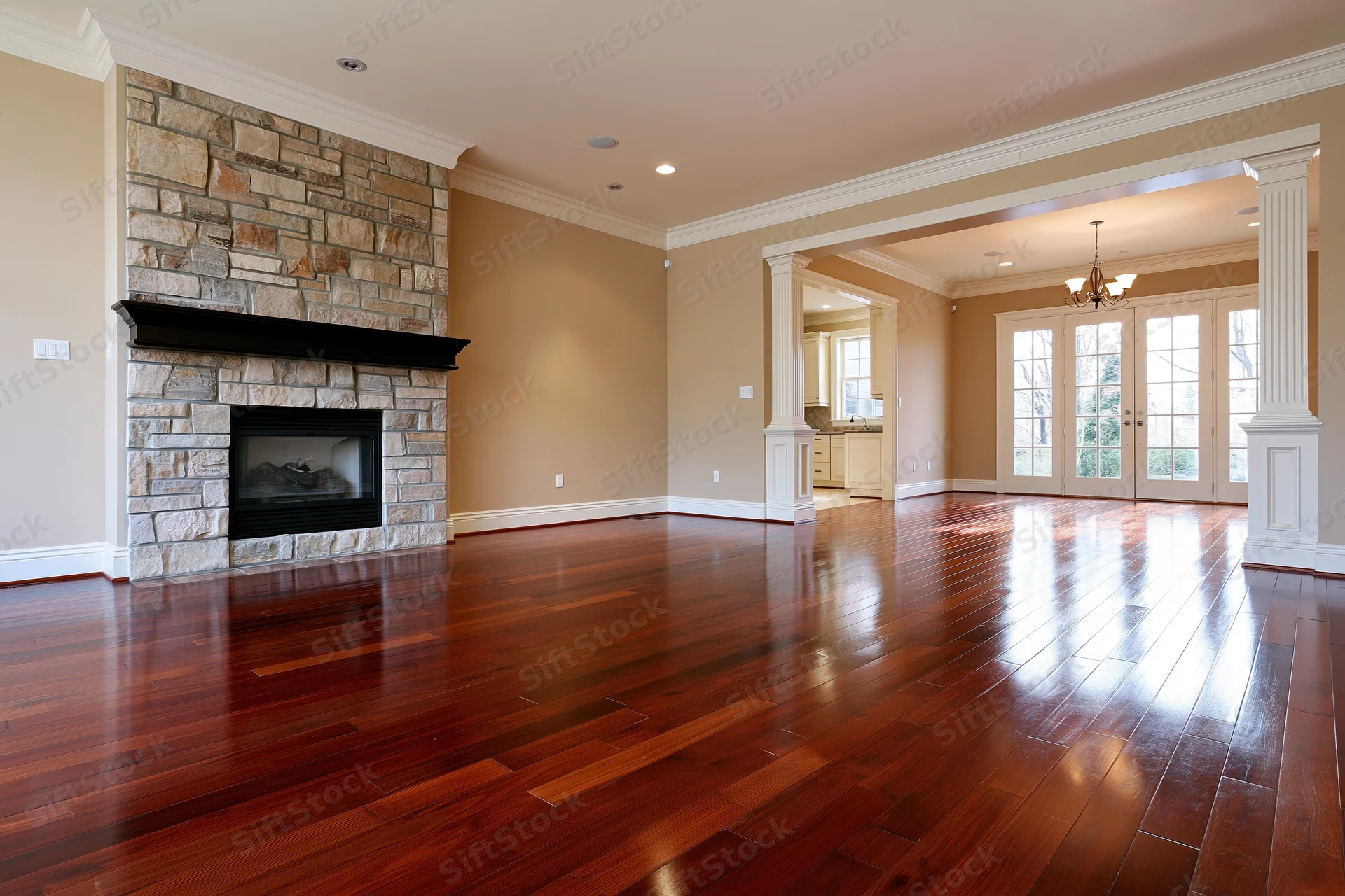 Empty luxury living room with dark cherry hardwood floor and stone fireplace
