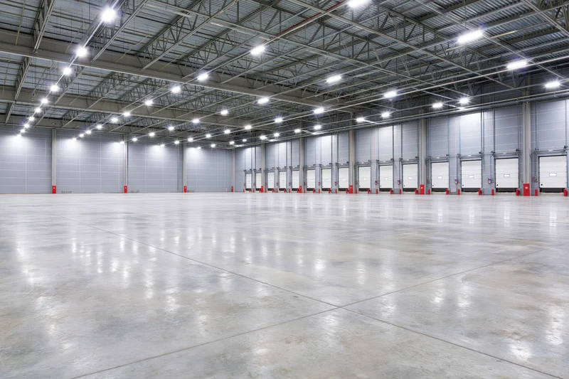 Empty modern warehouse interior with polished concrete floor and loading docks