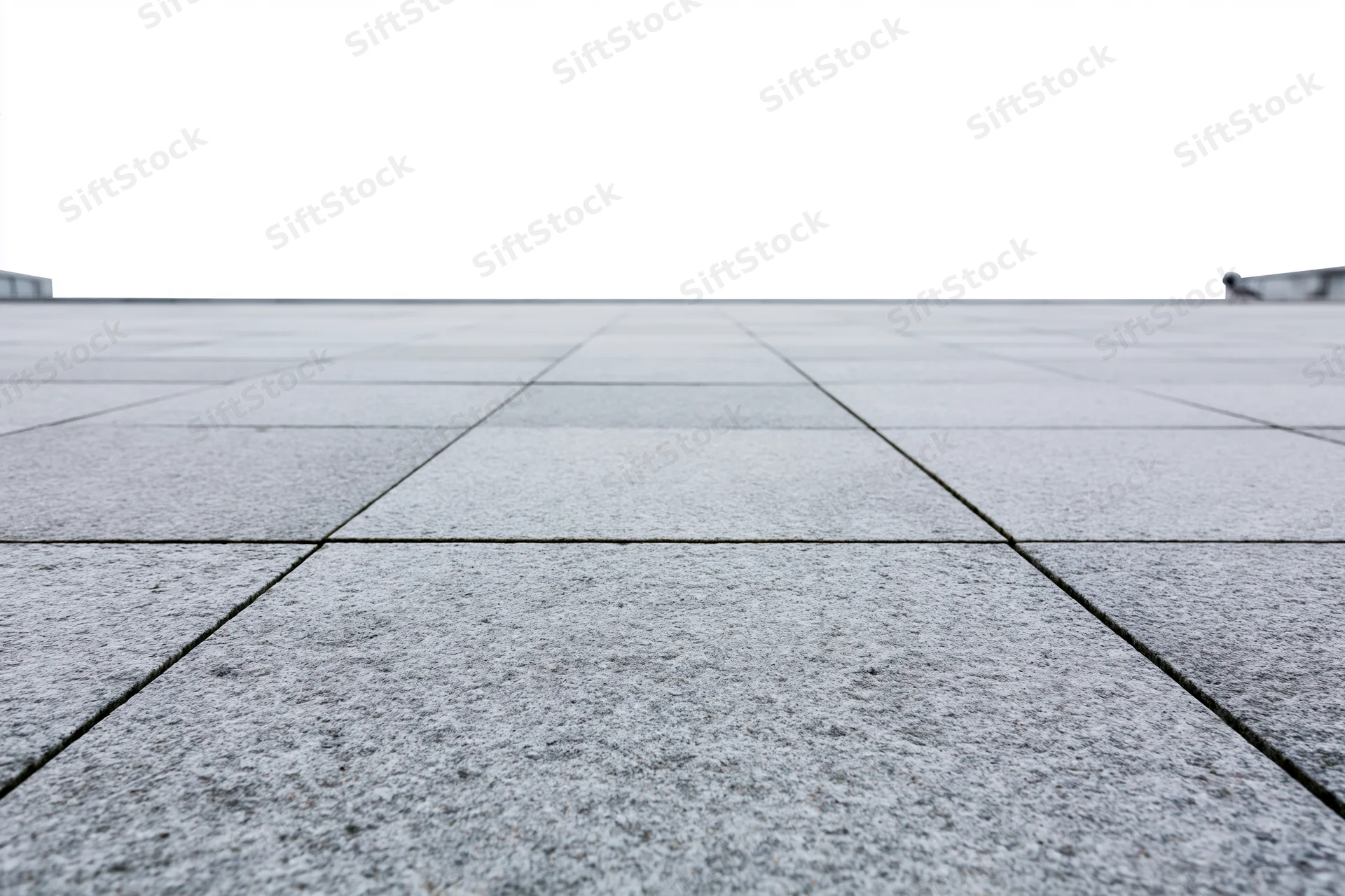 Stone tile plaza floor receding into the distance outdoors