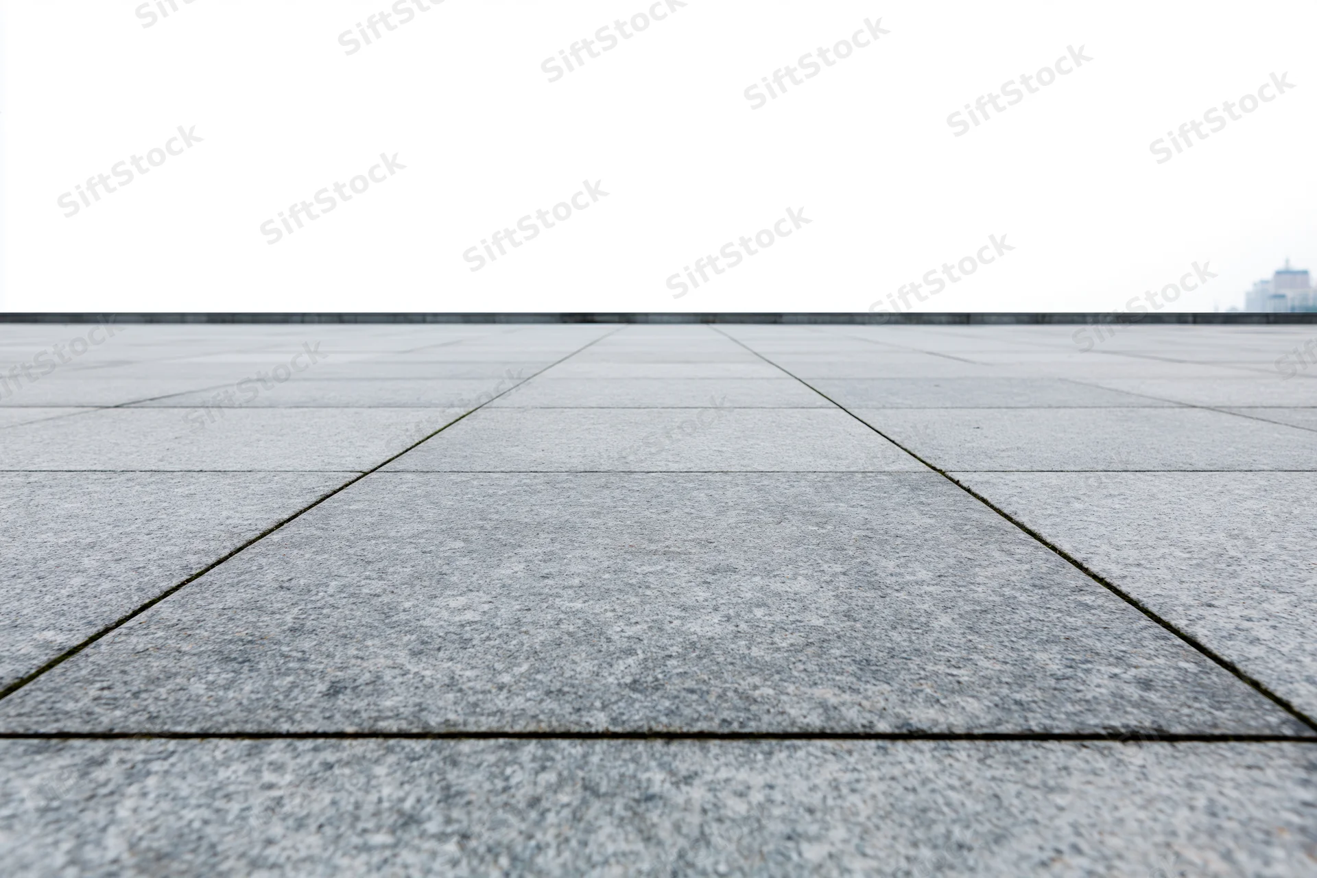 Stone tile pavement receding into the distance in an outdoor plaza