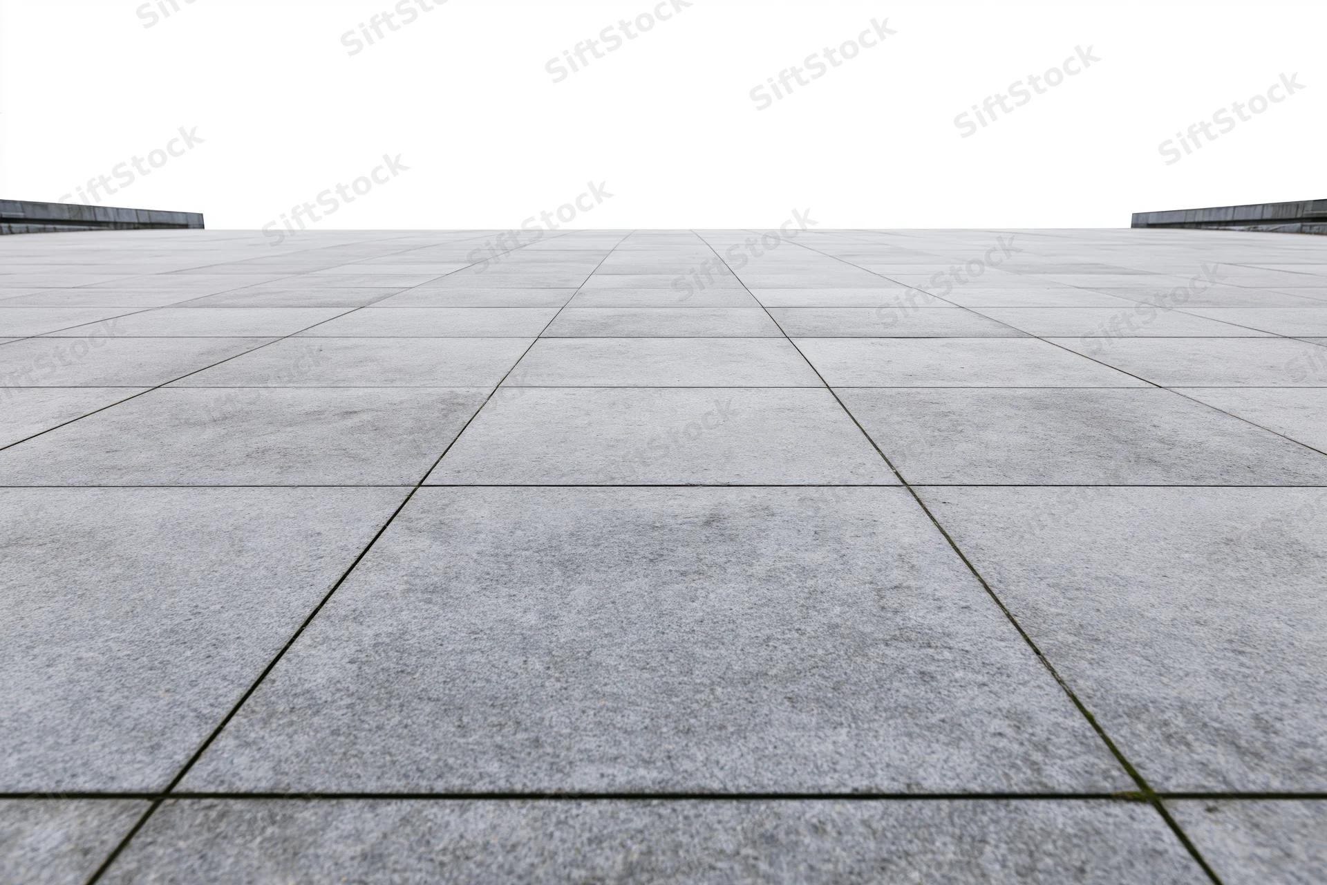 Large grey concrete paving stones arranged in a grid across an empty public plaza