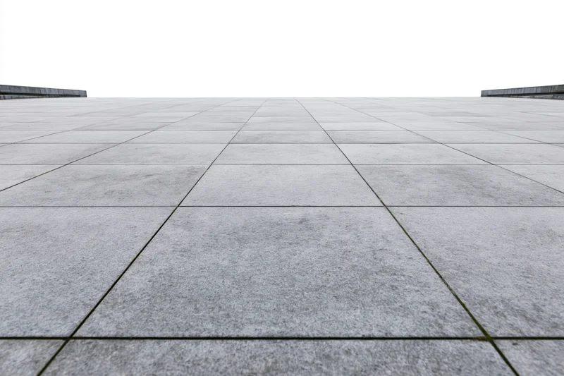 Large grey concrete paving stones arranged in a grid across an empty public plaza