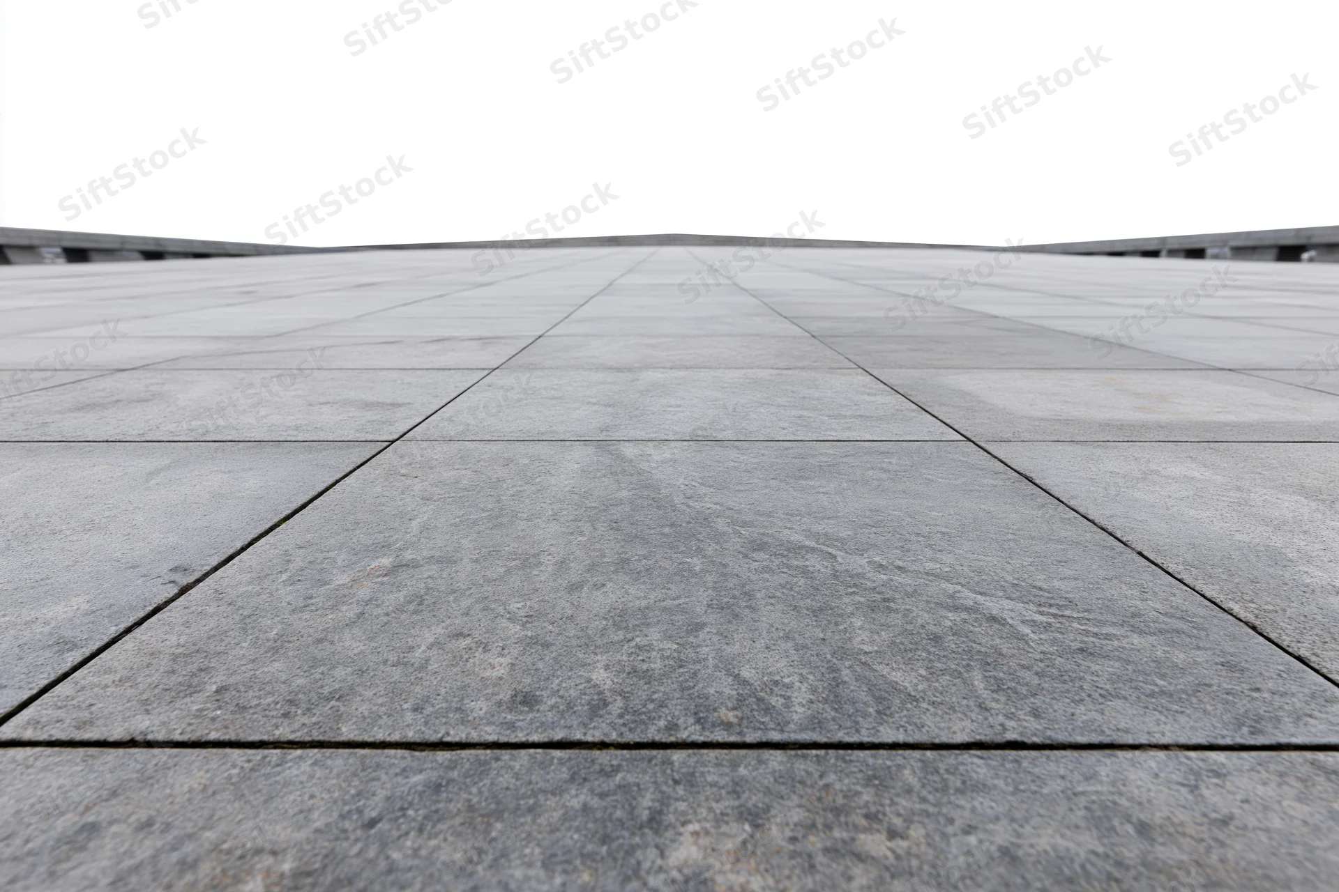 Large grey concrete paving stones arranged in a grid across an empty public plaza