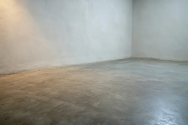 Empty room with bare concrete walls and smooth polished floor