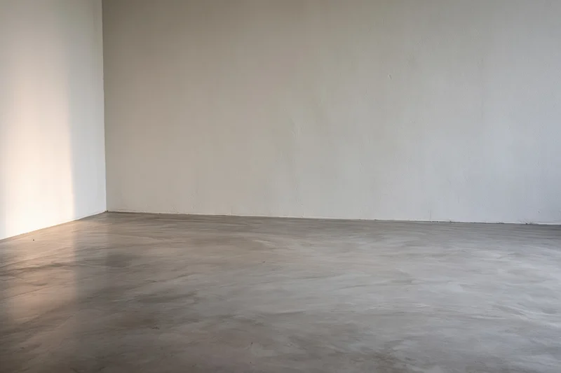 Empty room with smooth polished concrete floor and bare walls