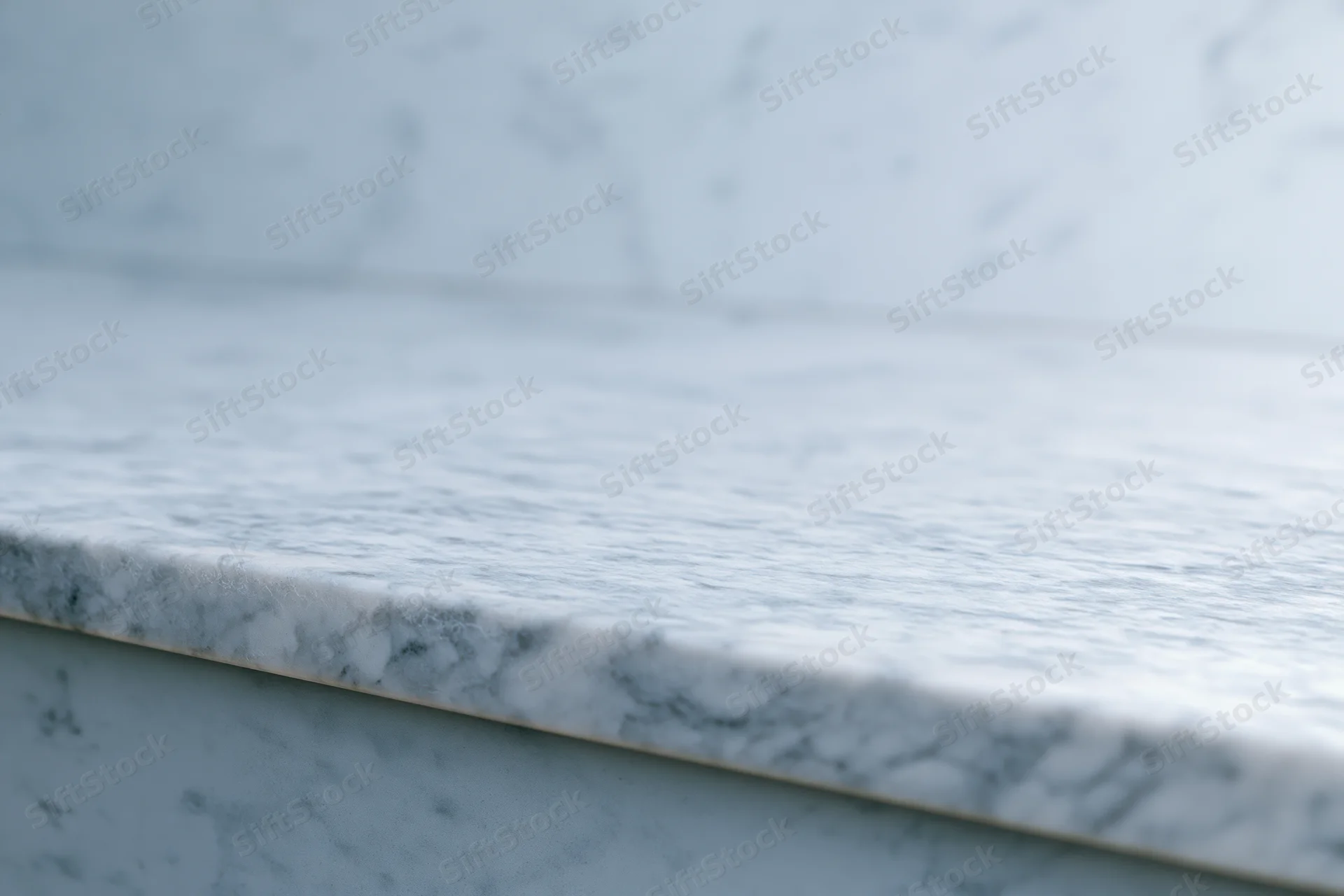 White marble countertop meeting a marble wall in a kitchen interior