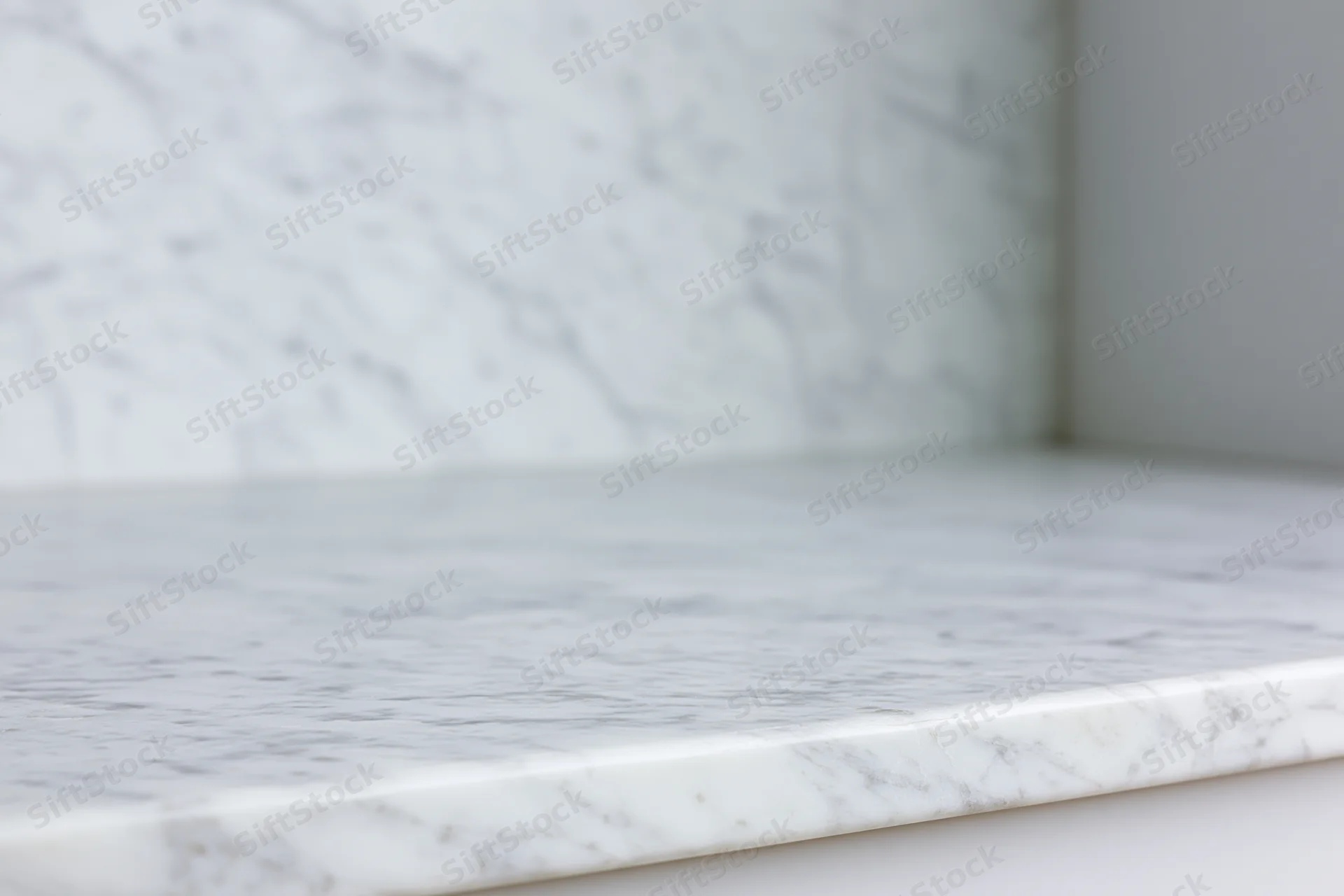 White marble countertop meeting a marble wall in a kitchen interior
