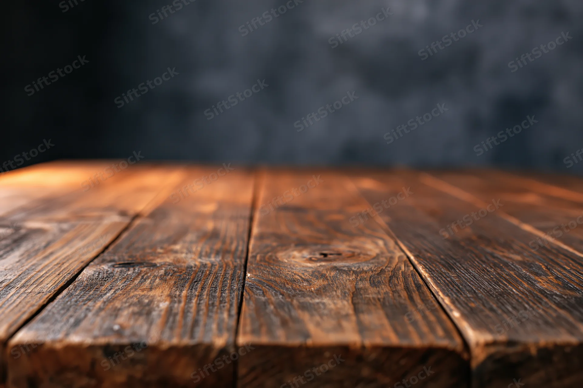 Empty wooden plank tabletop viewed from eye level with dark textured backdrop