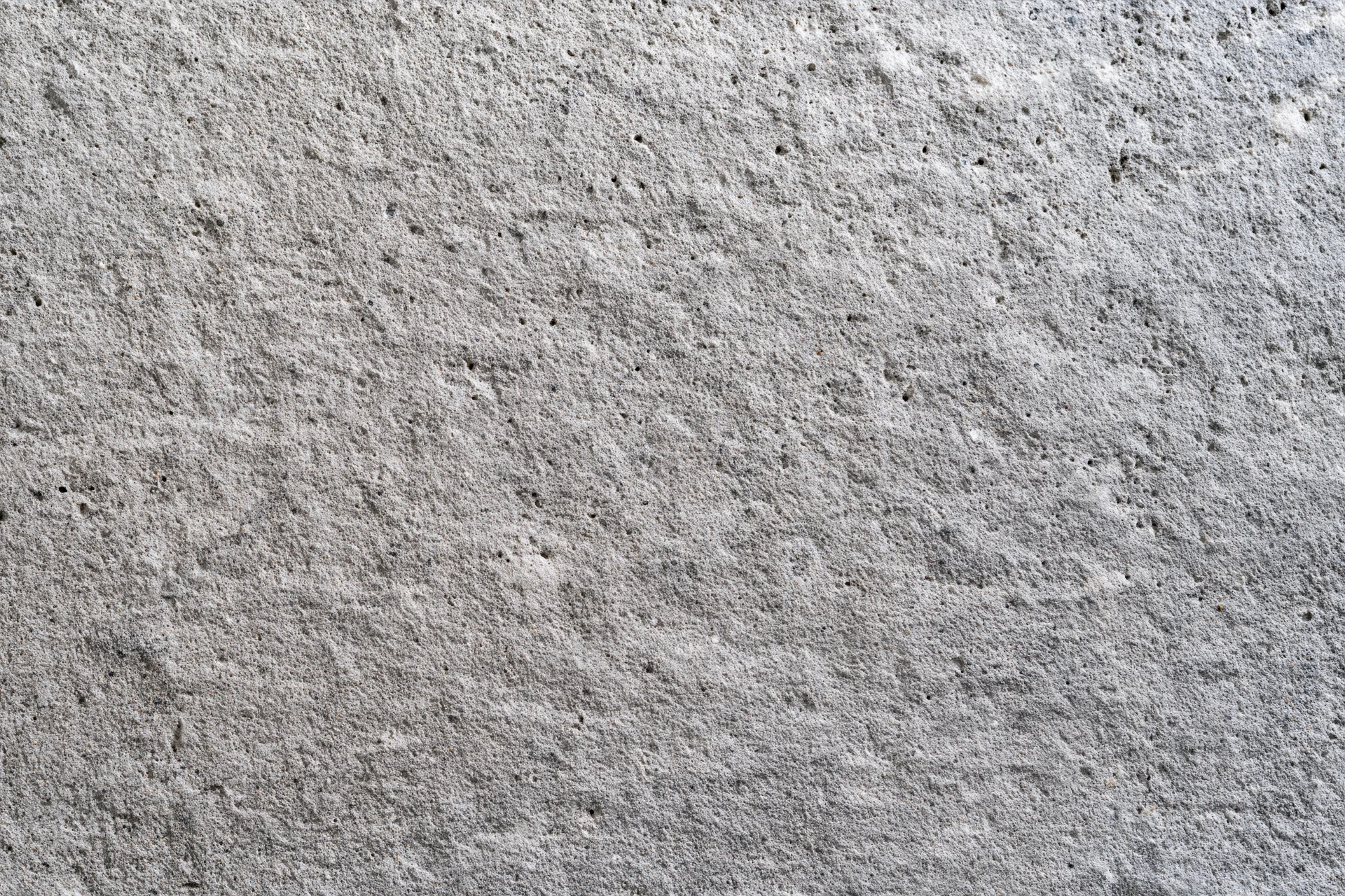Flat concrete wall surface filling the frame with rough texture and gray tone