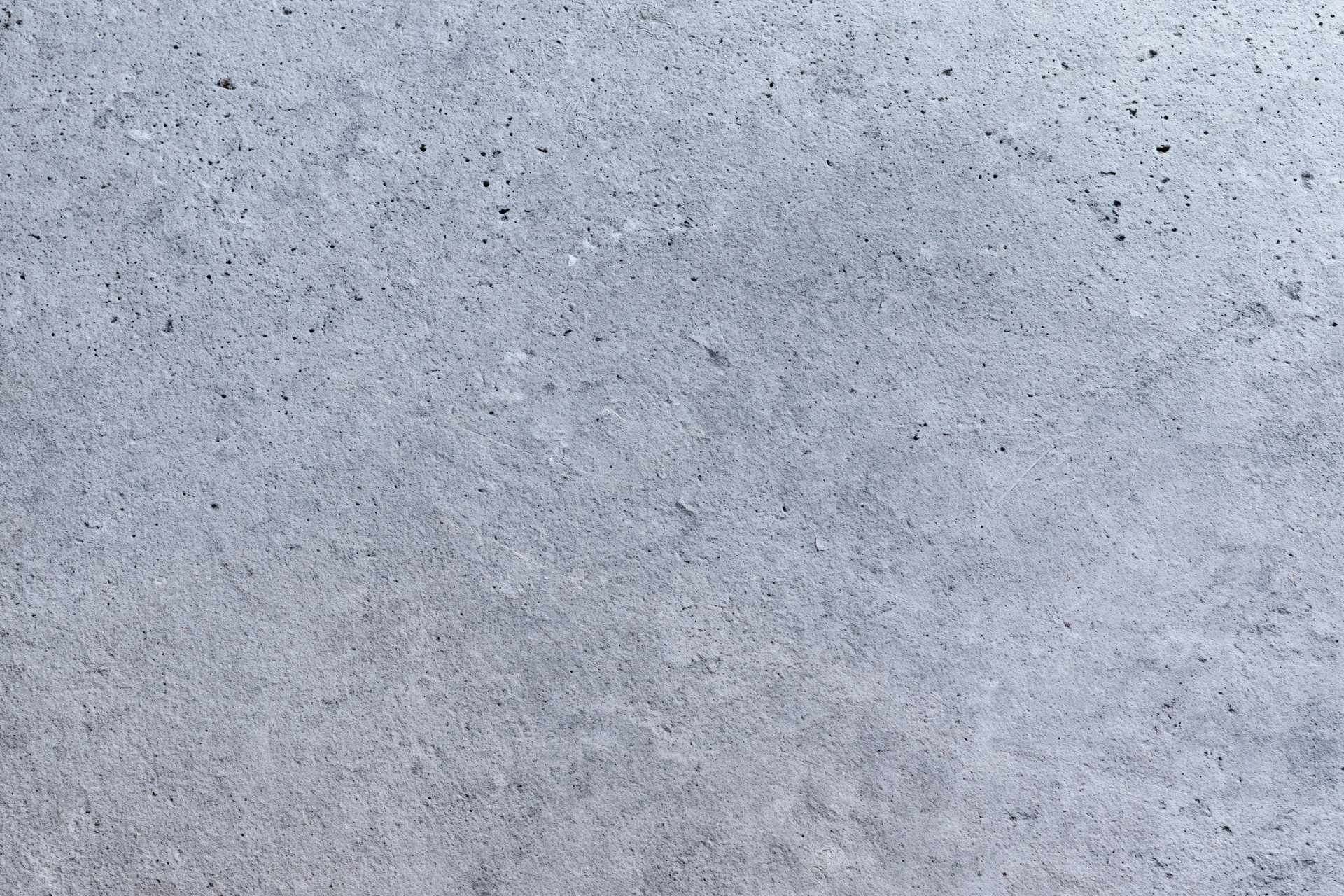 Flat concrete wall surface filling the frame with rough texture and gray tone