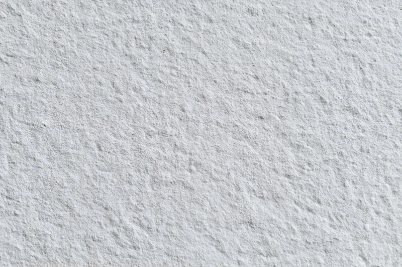 Flat concrete wall surface filling the frame with rough texture and neutral gray tone