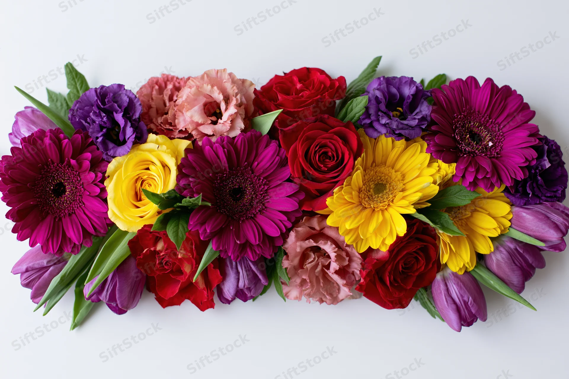 Flat lay arrangement of mixed cut flowers including gerbera daisies, roses, tulips, and carnations on white background