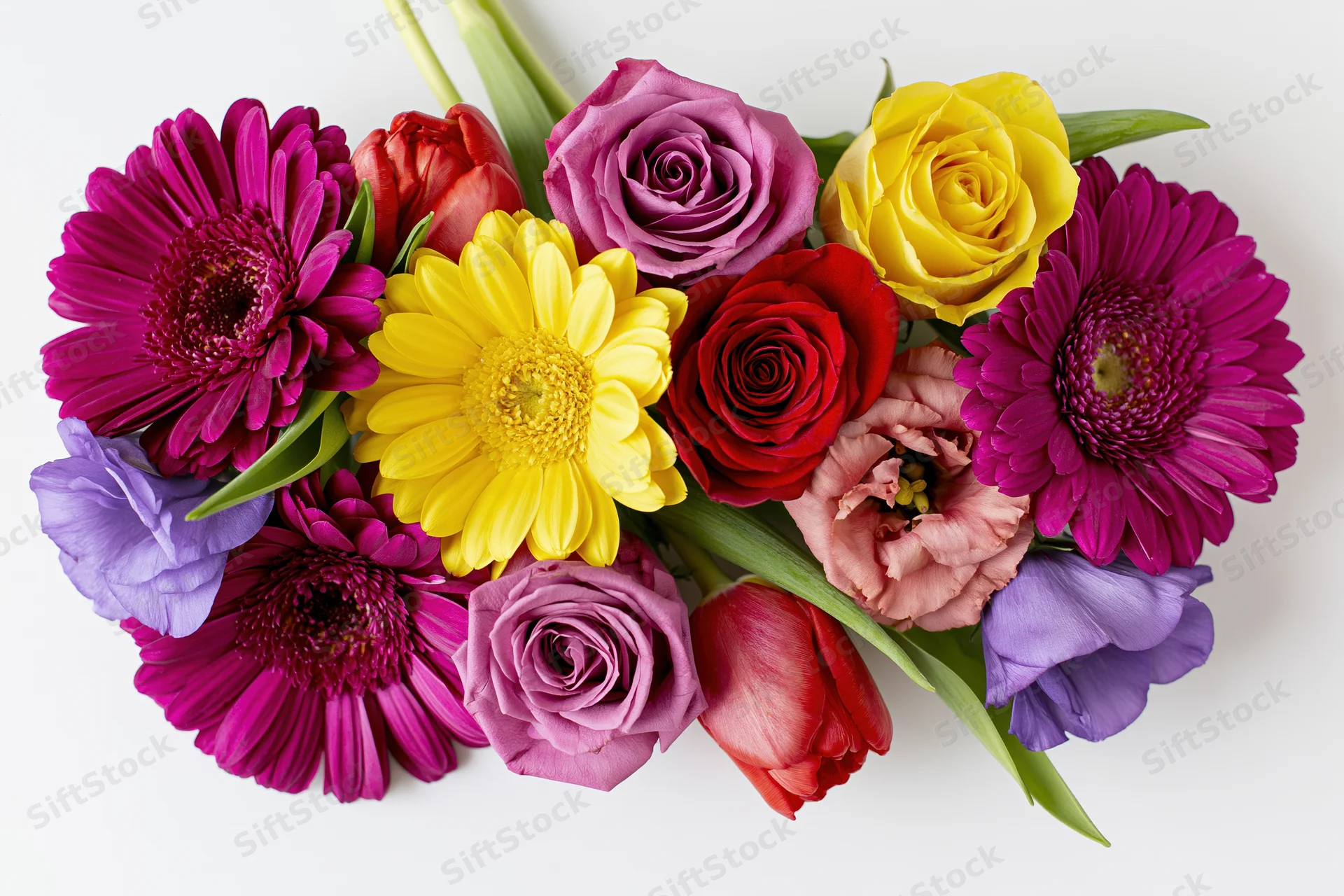 Flat lay arrangement of mixed cut flowers including gerbera daisies, roses, tulips, and ranunculus on white background