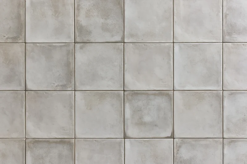 Concrete tile floor surface arranged in uniform grid pattern with grout lines