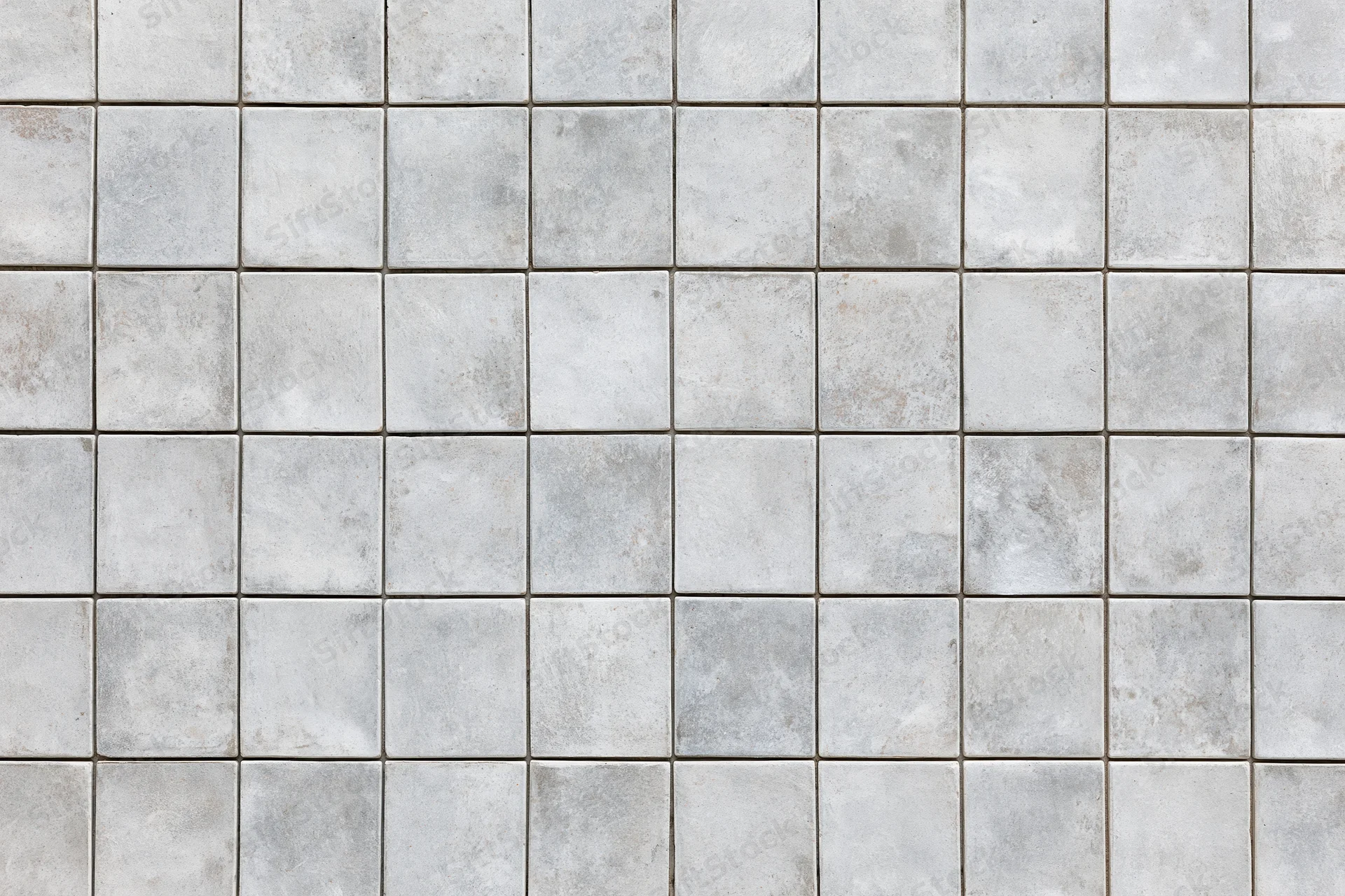 Close-up of a uniform concrete tile floor with gray grout in a grid pattern