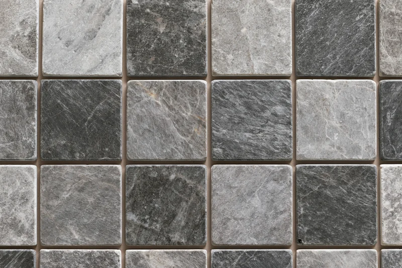 Grid of square stone tiles arranged in a mosaic pattern on a flat surface