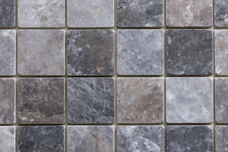 Grid of square stone tiles arranged in a mosaic pattern covering a flat surface