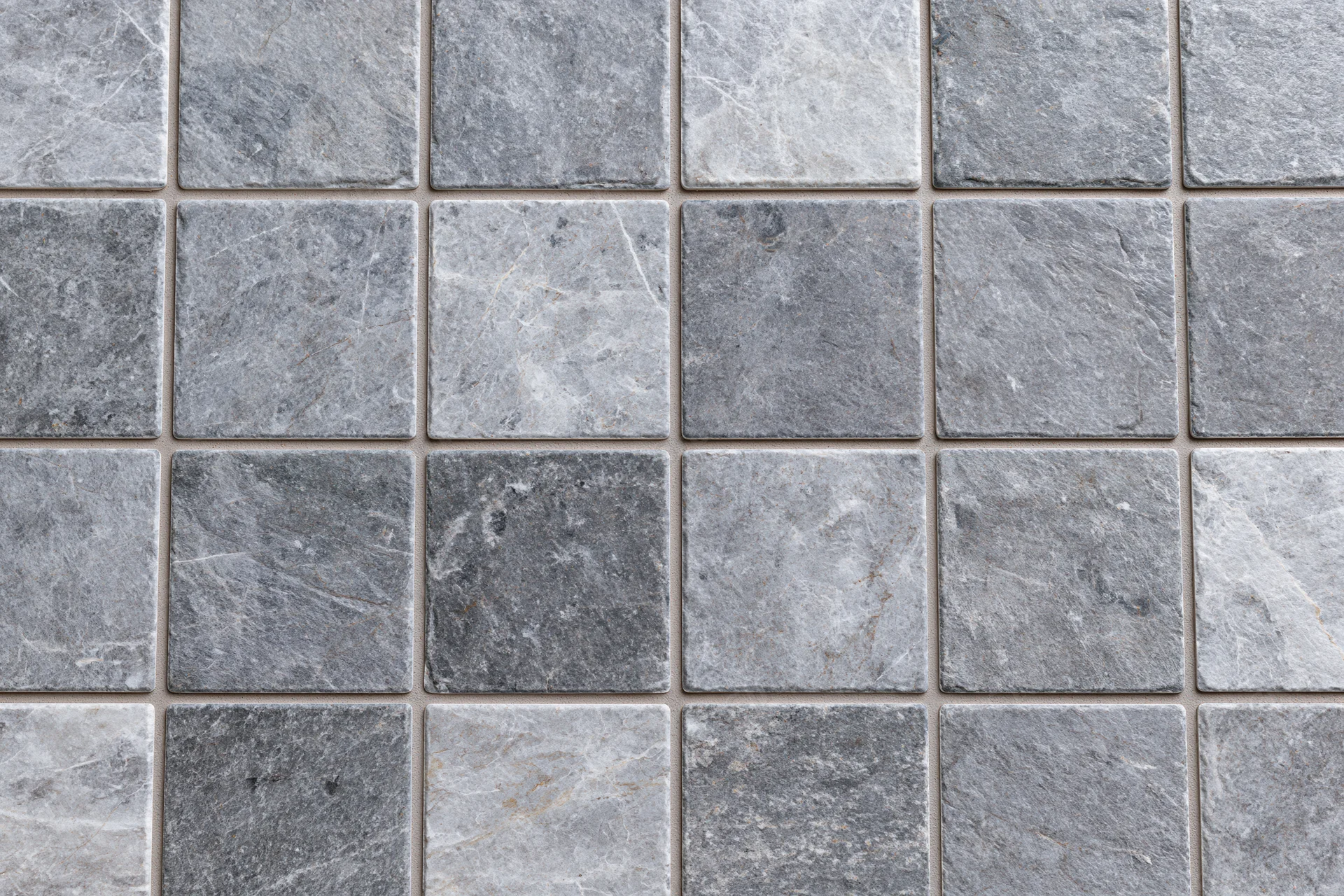Grid of square stone tiles arranged in a pattern covering a surface