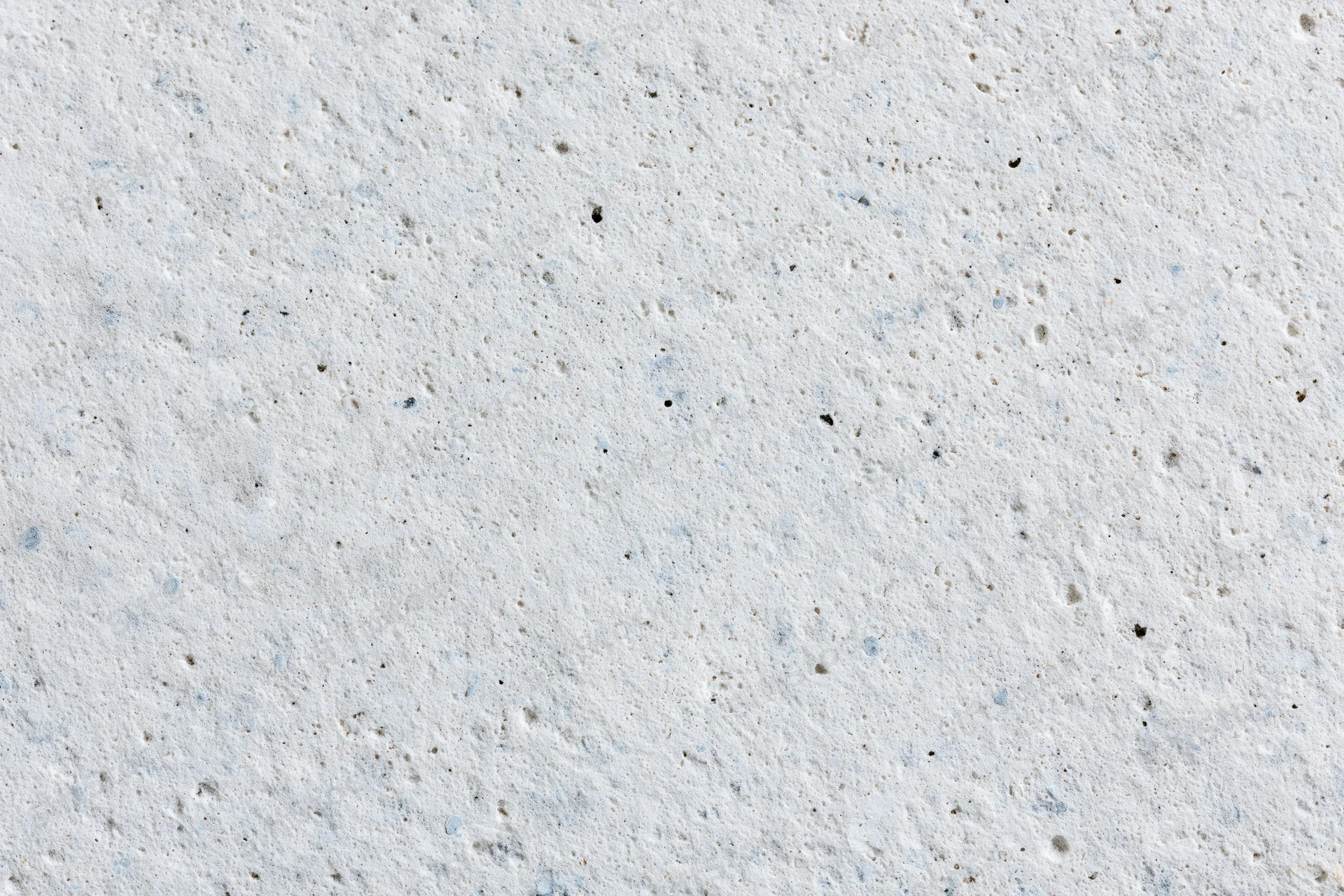 Close-up of a smooth concrete or limestone surface with natural texture and speckles