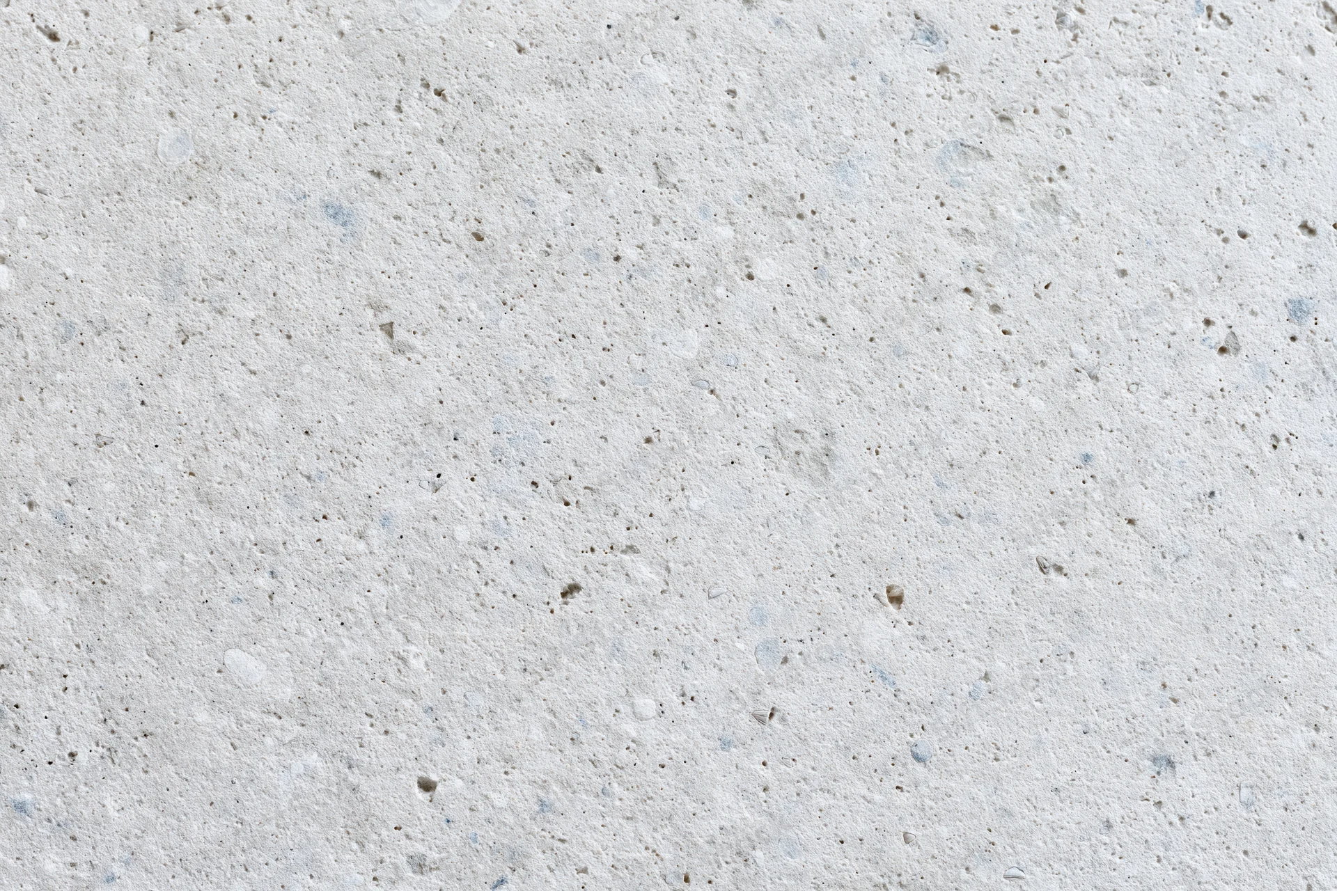 Close-up of a smooth concrete or limestone surface with natural texture and speckles