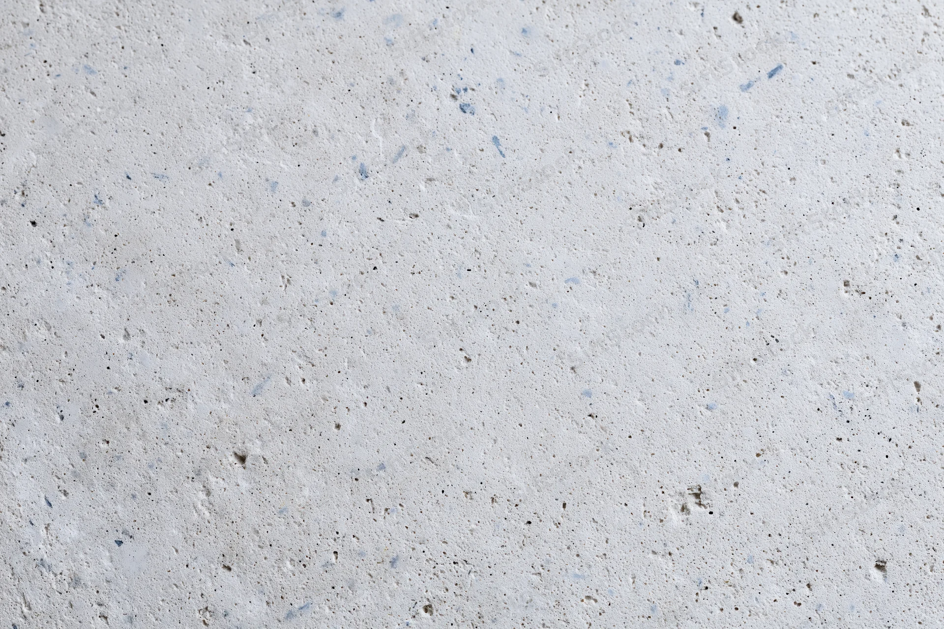 Close-up of a smooth concrete or limestone surface with natural speckles and pores