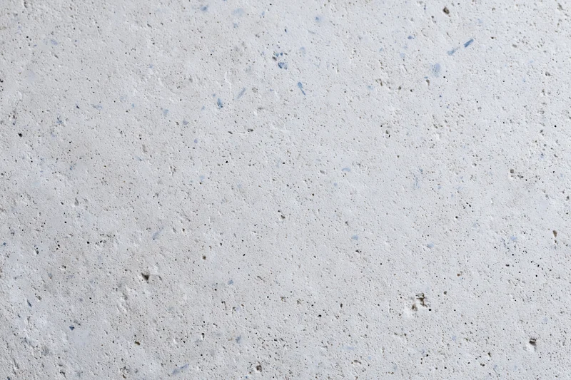 Close-up of a smooth concrete or limestone surface with natural speckles and pores