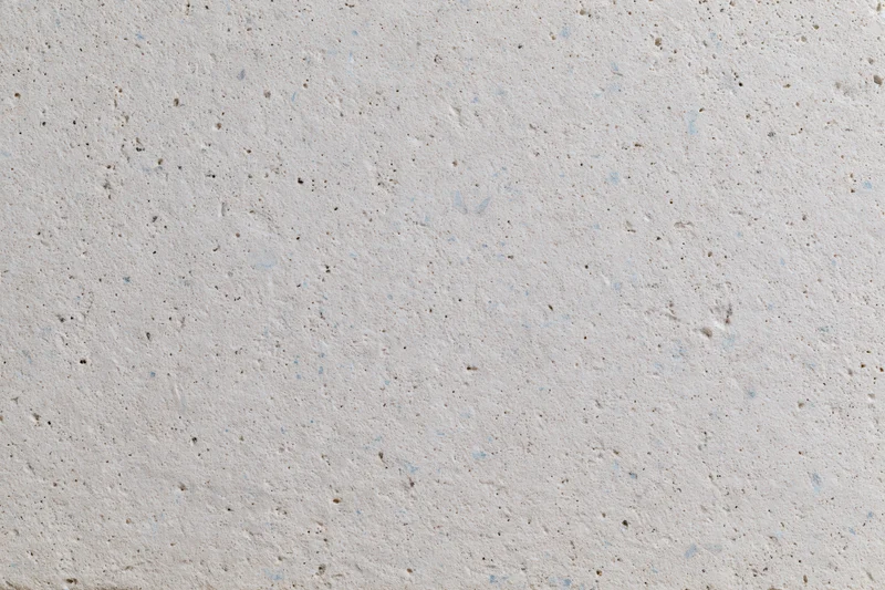 Close-up of a smooth concrete or limestone surface with natural speckles and pores