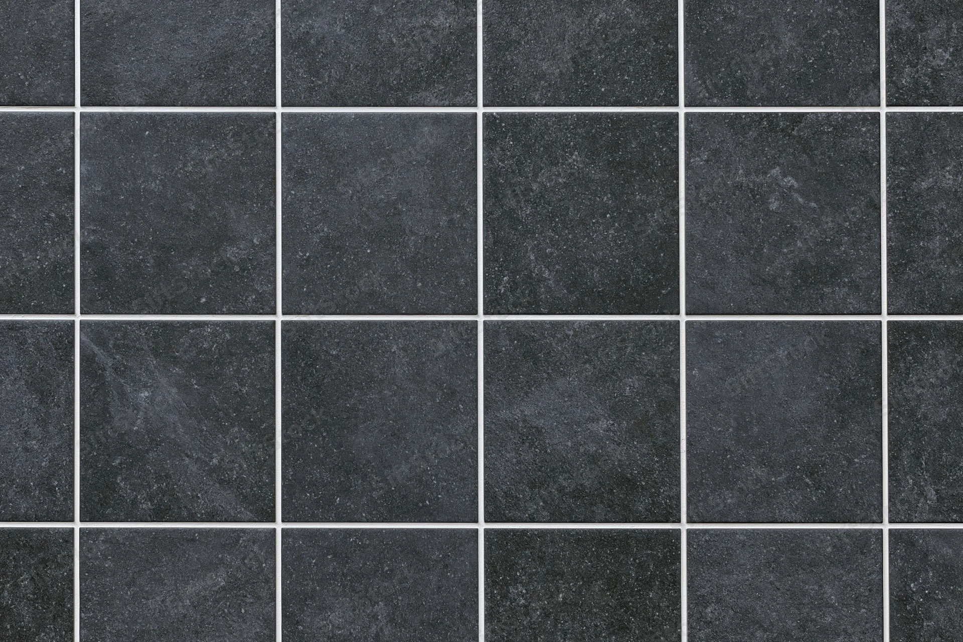 Dark charcoal ceramic floor tiles arranged in a grid pattern with white grout