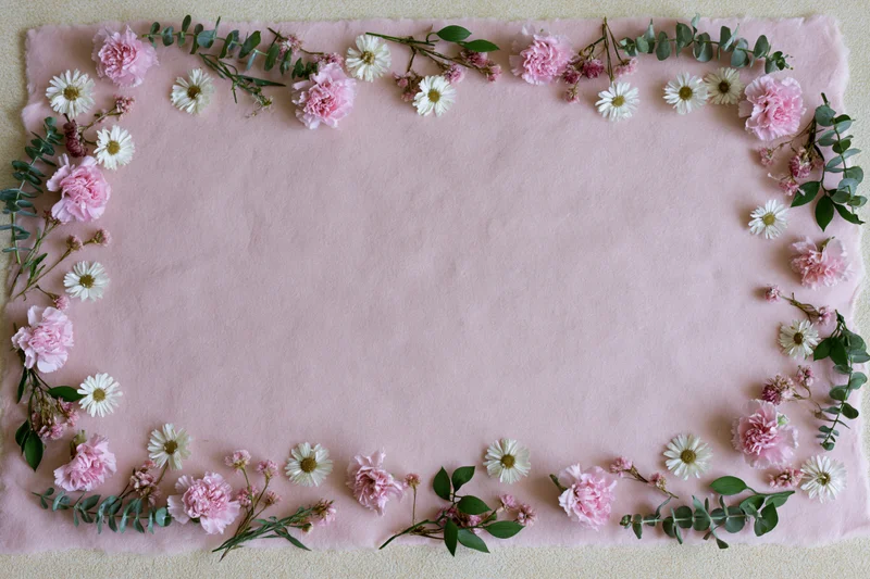 Flat lay of pink carnations white daisy blooms and greenery