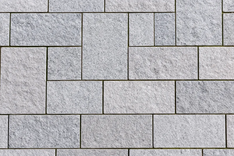 Gray stone pavers arranged in a geometric pattern for urban outdoor flooring
