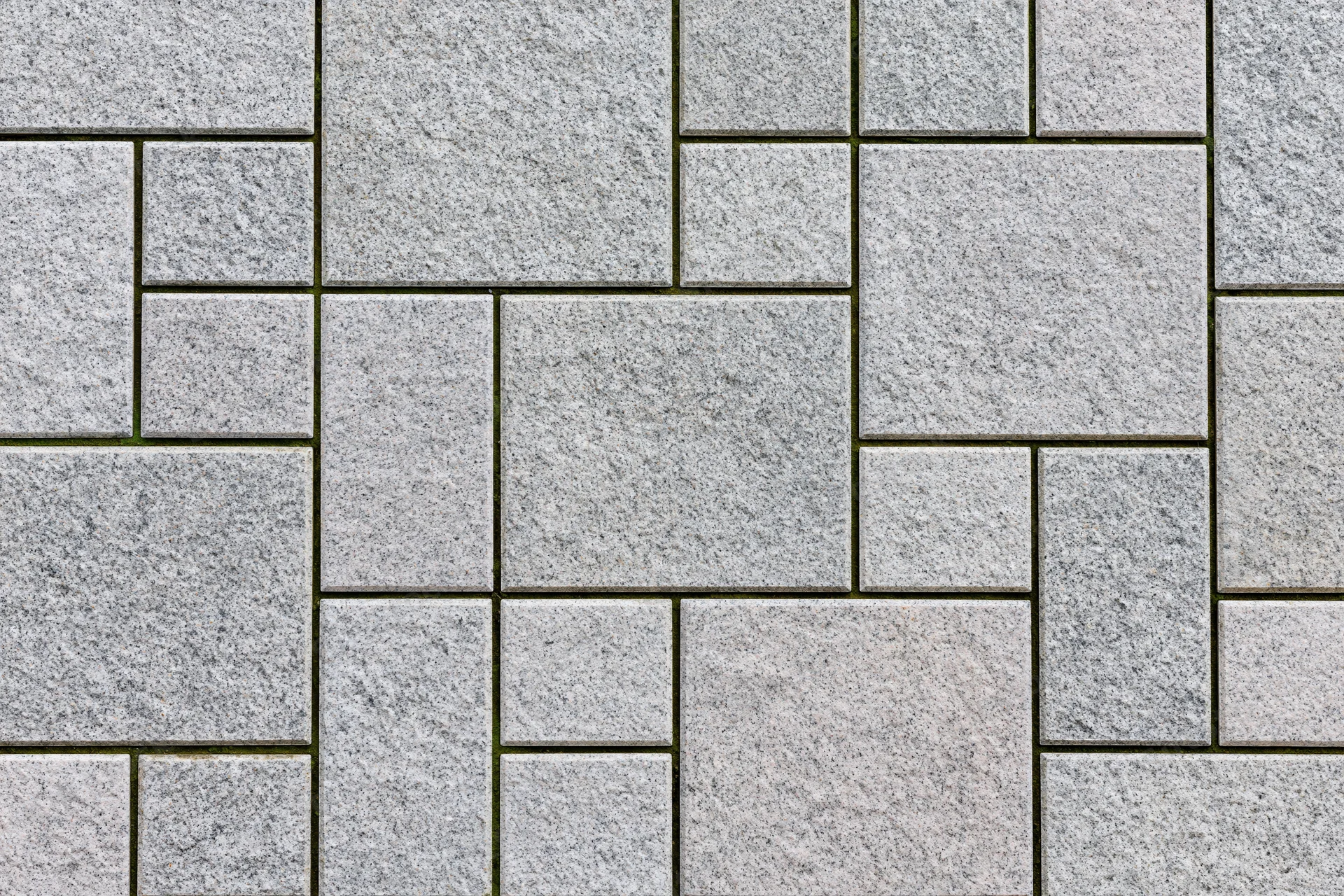 Gray stone pavers arranged in an interlocking pattern on an urban outdoor surface