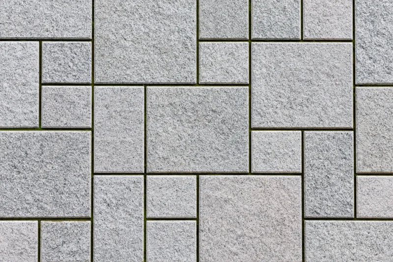 Gray stone pavers arranged in an interlocking pattern on an urban outdoor surface