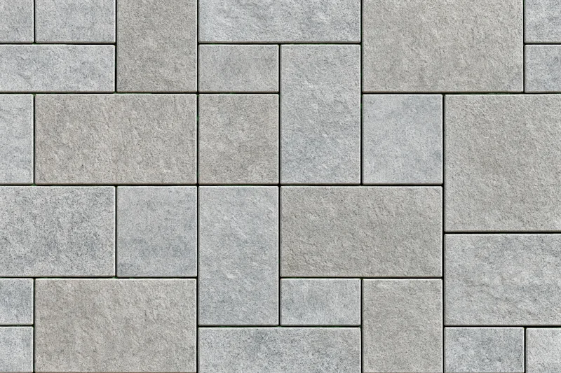 Stone pavers arranged in herringbone pattern on urban outdoor surface