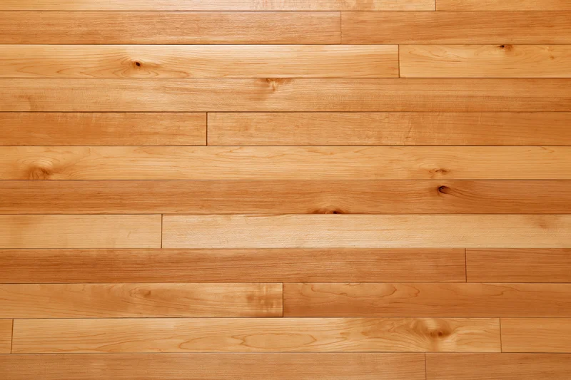 Horizontal hardwood strip flooring with natural wood grain and warm tone covering the floor surface