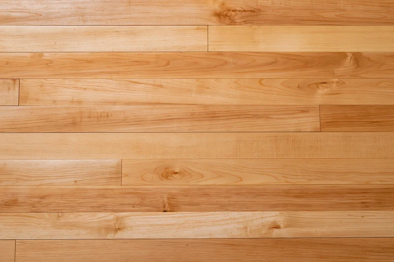 Horizontal hardwood strip flooring with natural wood grain and warm light brown finish